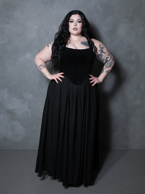 A model in a poised, elegant stance highlighting the seamless paneling and reinforced stitching of this exquisite black velvet garment.