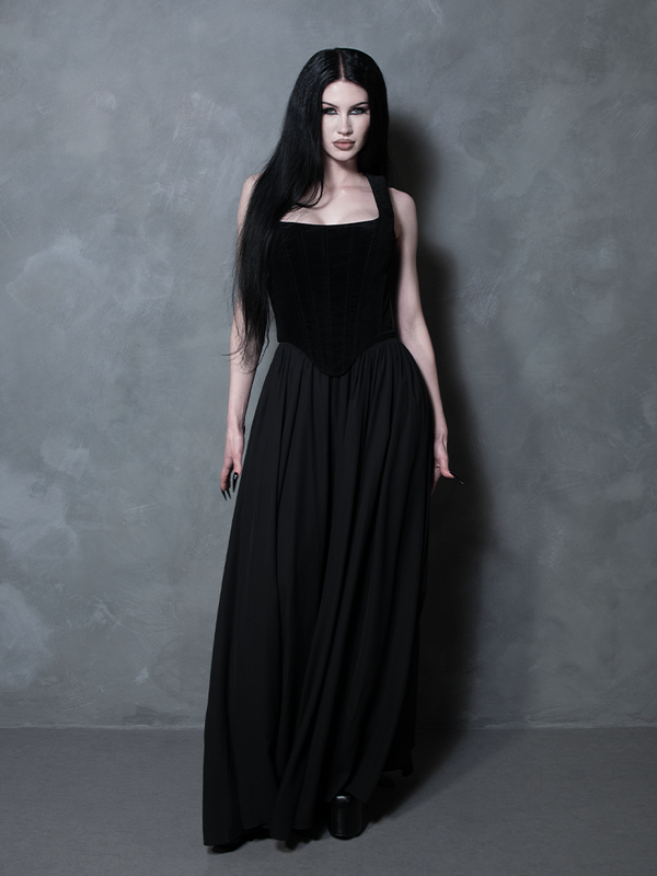 Imbued with a sense of vintage noir, a female model effortlessly demonstrates the high-fashion impact of a sweeping black gothic skirt rooted in dark romance.