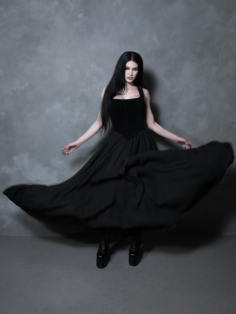 Enveloped in light, fluid fabric, a female model exudes effortless grace and high-fashion poise in a stunning black maxi skirt built for dramatic nocturnal storytelling.