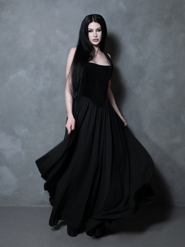 An ethereal embodiment of dark elegance, a female model commands attention in this exquisite black chiffon maxi skirt, perfectly capturing the essence of modern gothic glamour and dramatic, high-fashion storytelling.
