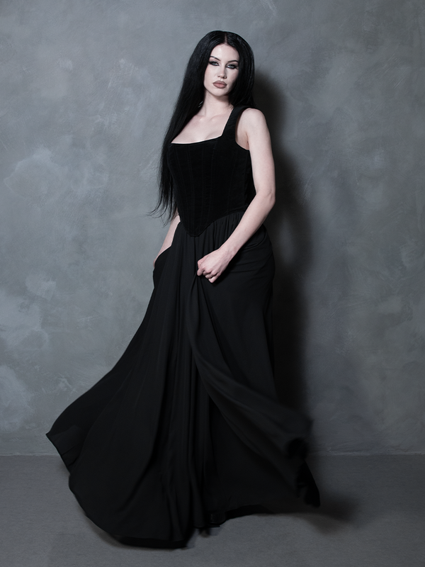 Perfect for the modern vixen, a female model elevates high-fashion gothic apparel in a striking sheer black maxi skirt that balances a delicate weave with deep mystery.