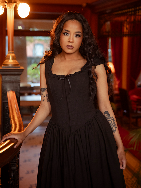 A relic of dark romance, this antique black dress drapes in silken shadows, perfect for twilight trysts or candlelit confessions.