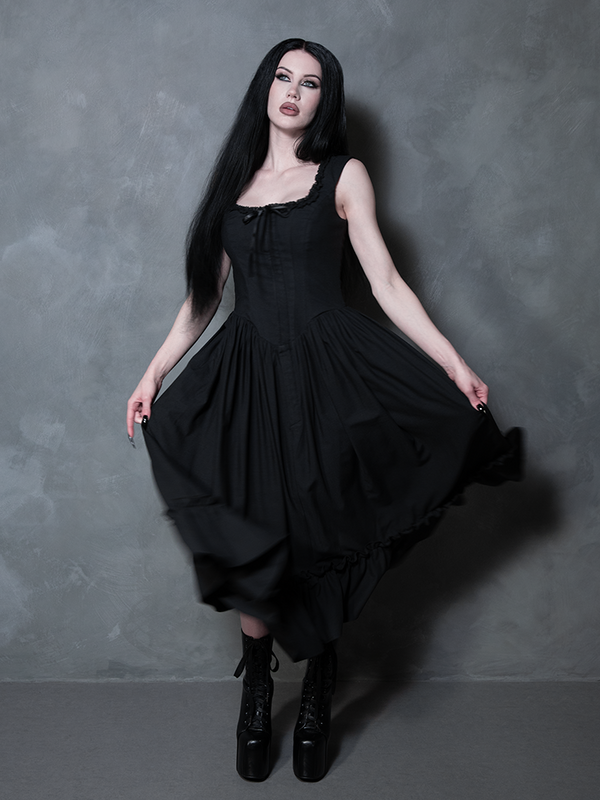 A female model evokes the spirit of a dark fairy tale while wearing the dreamy, romantic Nightshade Underpinning Dress in Antique Black.