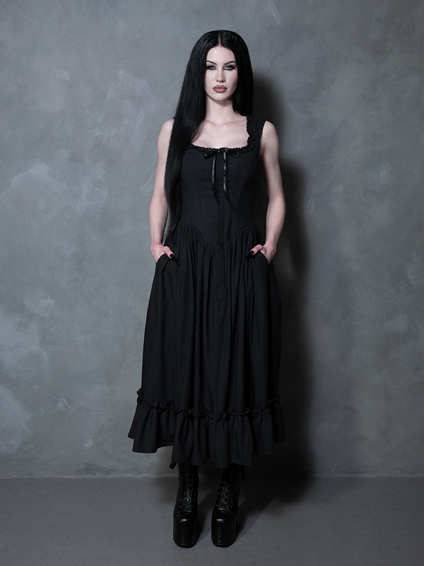A female model showcases a look drenched in dark elegance, her presence elevated by the Nightshade Underpinning Dress in Antique Black.