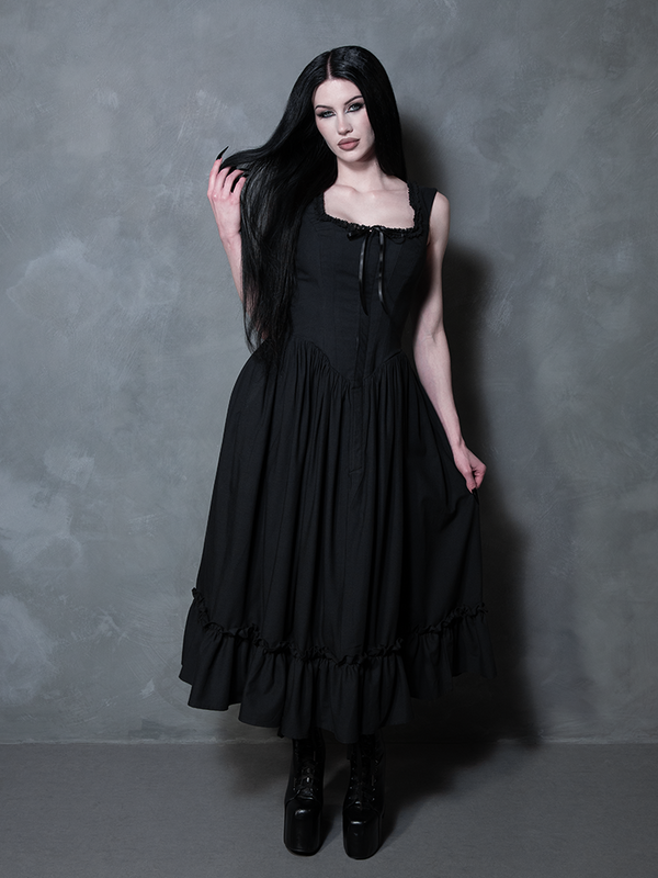 A female model channels a ghostly, romantic poetry while draped in the breathtaking Nightshade Underpinning Dress in Antique Black.
