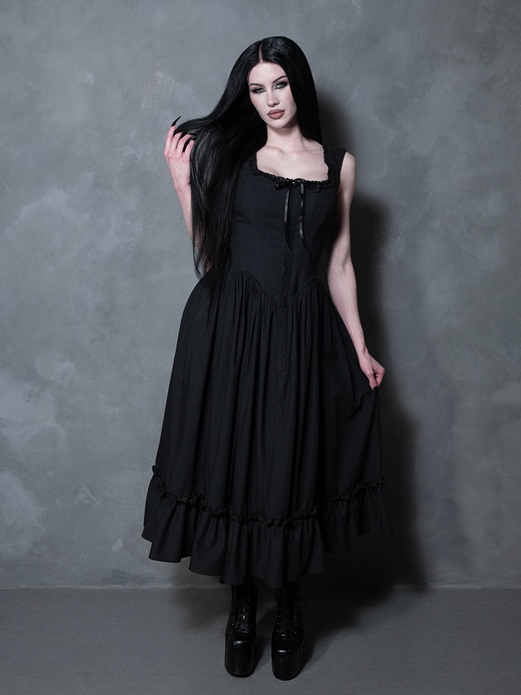 A female model channels a ghostly, romantic poetry while draped in the breathtaking Nightshade Underpinning Dress in Antique Black.