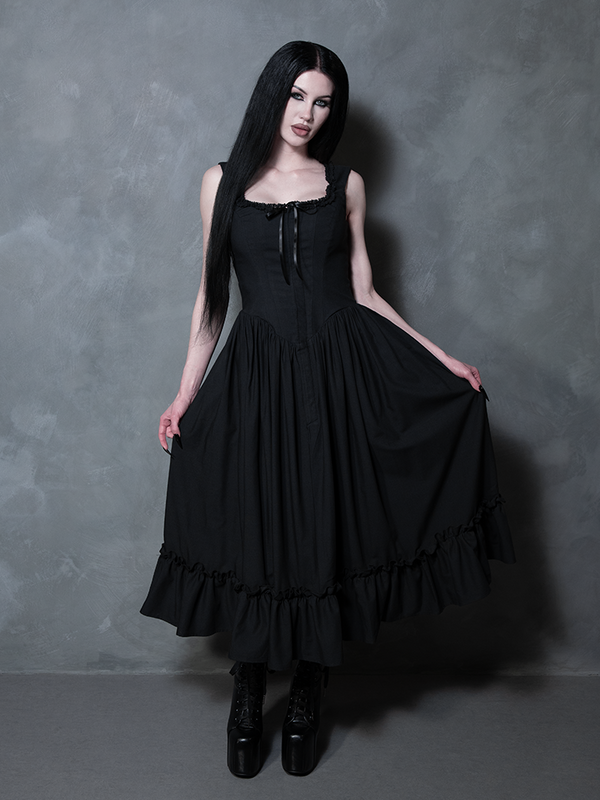 A female model embraces her inner witchy aesthetic, looking perfectly untamed yet refined in the Nightshade Underpinning Dress in Antique Black.