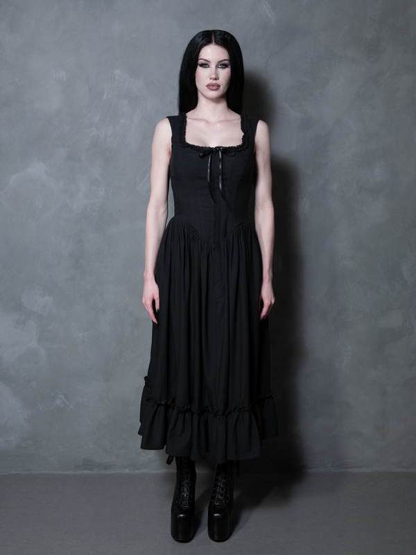 A female model stands as a testament to timeless alternative beauty in the Nightshade Underpinning Dress in Antique Black.