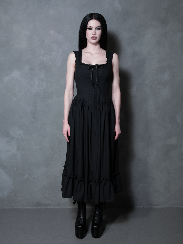 A female model stands as a testament to timeless alternative beauty in the Nightshade Underpinning Dress in Antique Black.