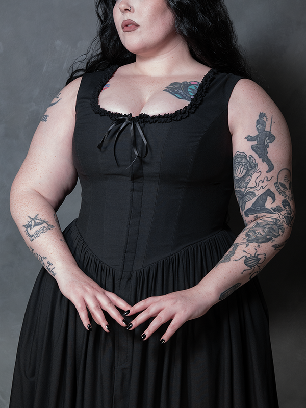Cloaked in the rich, deep tones of the Nightshade Underpinning Dress in Antique Black, a female model steps out as a vision of romantic gothic luxury.