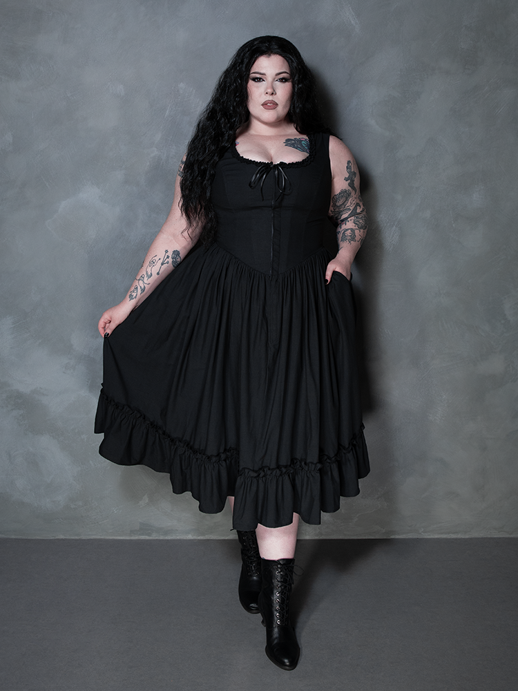 The epitome of dark luxury is achieved as a female model wears the exquisite Nightshade Underpinning Dress in Antique Black.