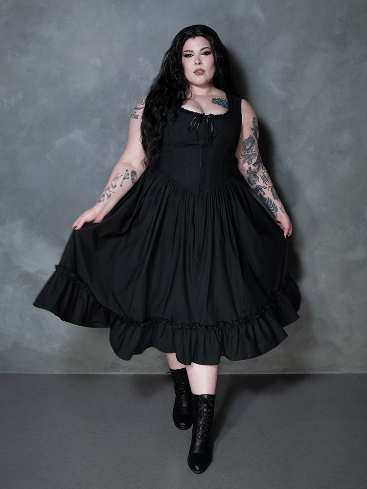 Infused with antique charm and Victorian Goth sensibilities, a female model wears the spectacular Nightshade Underpinning Dress in Antique Black.