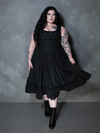 Seamlessly blending alternative edge with high-end luxury, a female model showcases the Whimsigoth charm of the Nightshade Underpinning Dress in Antique Black.