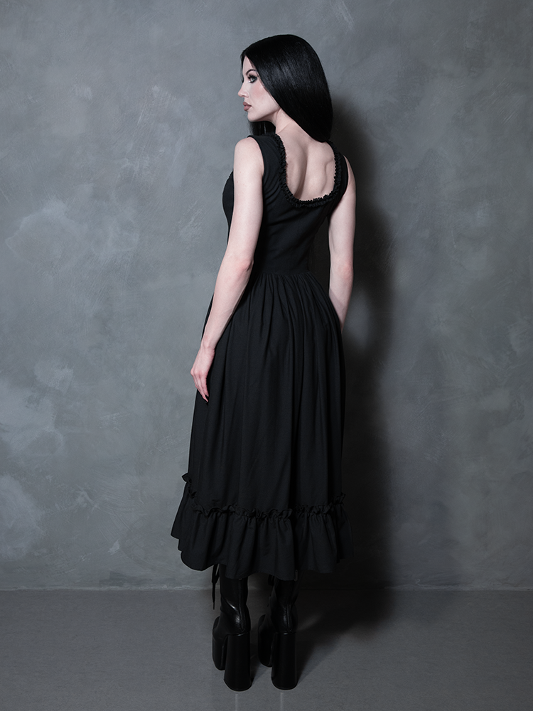 Draped in the moody elegance of the Nightshade Underpinning Dress in Antique Black, a female model exudes absolute gothic glamour.