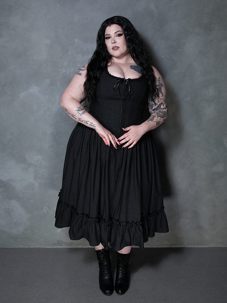 A female model channels a deep, brooding sophistication while styled in the magnificent Nightshade Underpinning Dress in Antique Black.