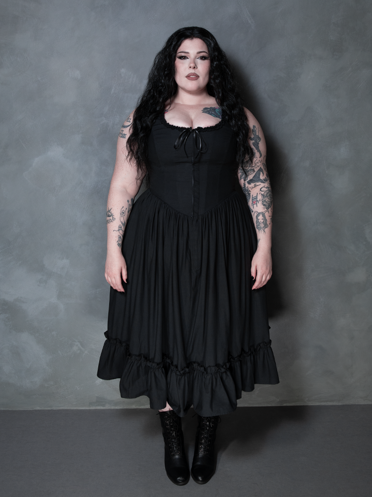 A female model channels an alluring, vampiric romance while styled in the decadent Nightshade Underpinning Dress in Antique Black.