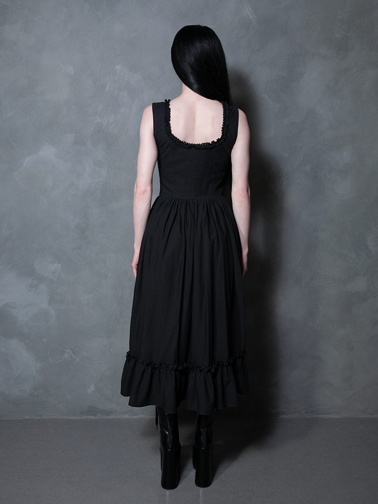 Exuding a sultry, mysterious confidence, a female model looks effortlessly chic in the Nightshade Underpinning Dress in Antique Black.