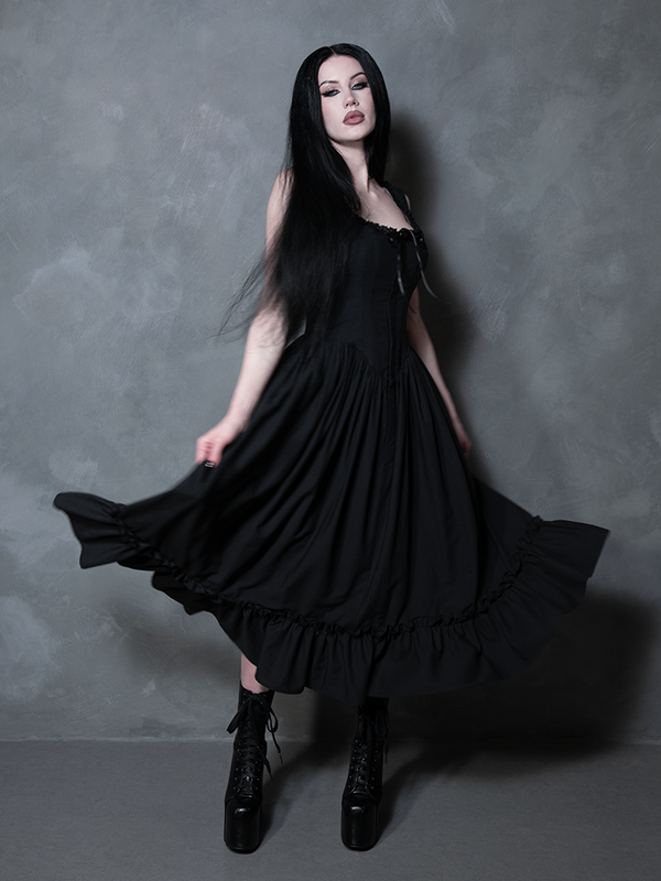 A female model beautifully merges historical romance with modern style, wearing the Victorian Goth inspired Nightshade Underpinning Dress in Antique Black.