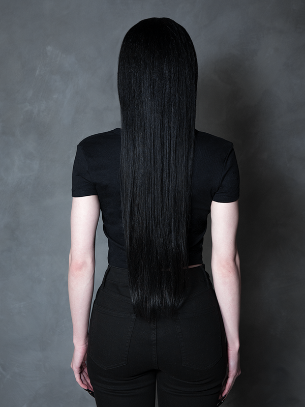 Enveloped in nocturnal mystery, a model styled in dramatic gothic clothing captures the ultimate essence of classic noir horror with a striking, form-flattering black tee.