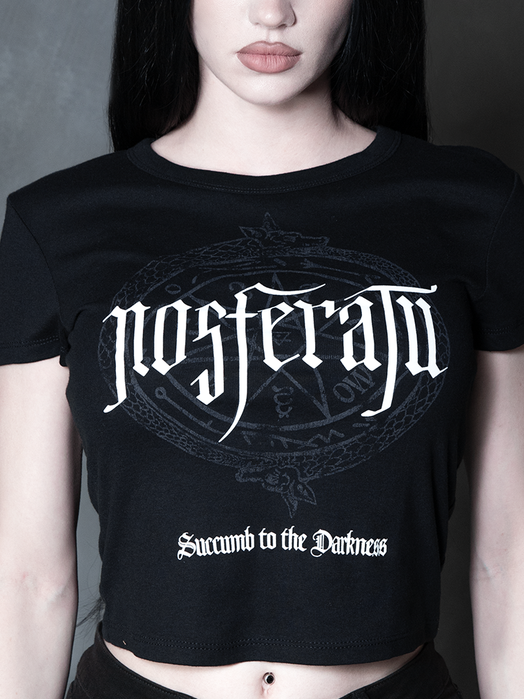Steeped in romantic melancholy, a model styled in Whimsigoth inspired clothing showcases a sleek, form-fitting black graphic tee that captures the timeless spirit of gothic horror.