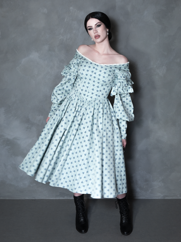 Exuding an exquisite Victorian Goth aesthetic, a female model seamlessly blends vintage darkness with modern alternative fashion in a hauntingly elegant floral print gown.