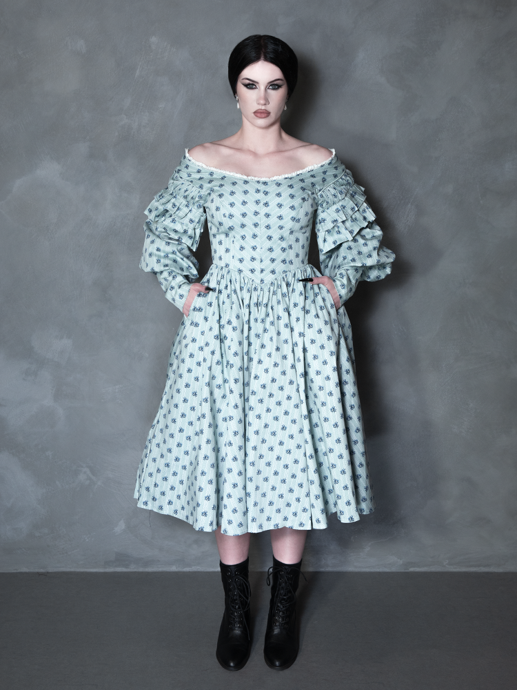 A female model channels high-fashion vampire romance, her darkly enchanting ensemble centered around a premium piece of gothic apparel bearing a sinister yet beautiful botanical pattern.