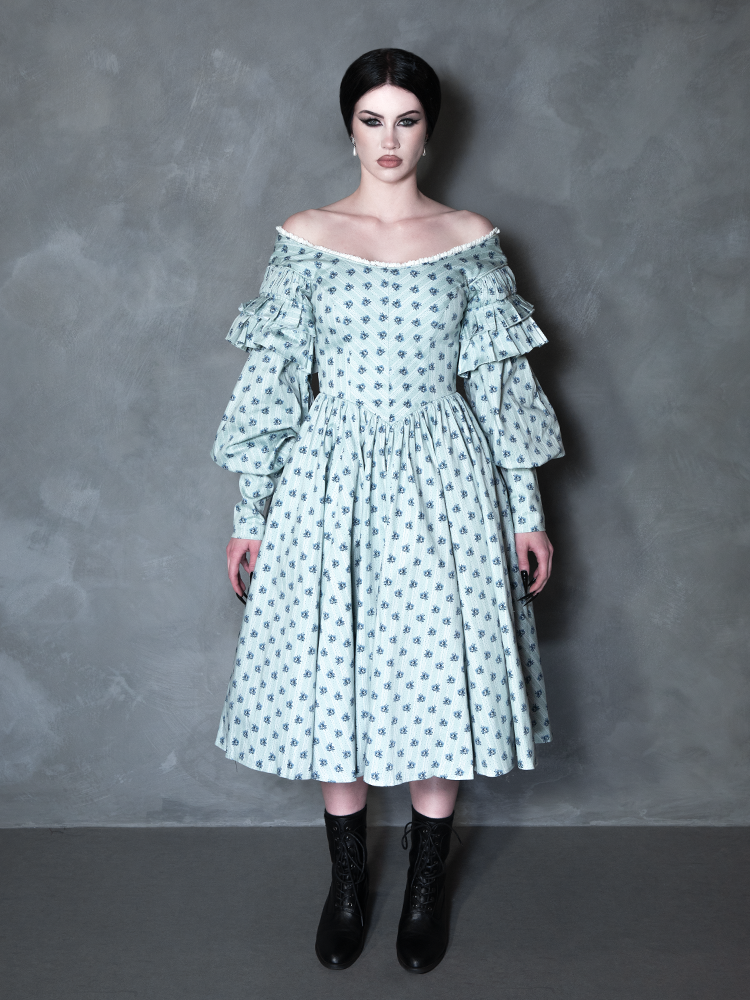 A gothic glamour muse radiates sophisticated darkness, her romantic alternative outfit perfectly complemented by an intricate, vintage-inspired patterned gown.