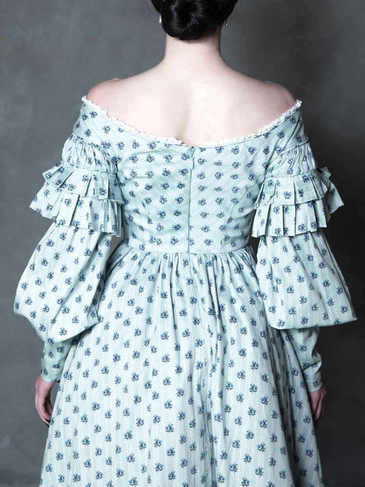 A model effortlessly blends regal comfort with a high-fashion Victorian Goth allure, showcasing a dramatic, midnight-blue patterned gown perfect for moonlit strolls.