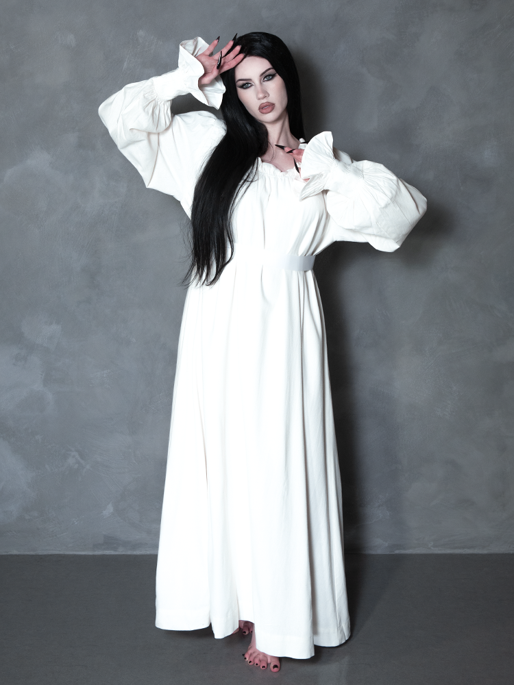 Steeped in atmospheric shadow, a female model elevates traditional gothic clothing trends into a grand display of wearable art and spellbinding luxury.