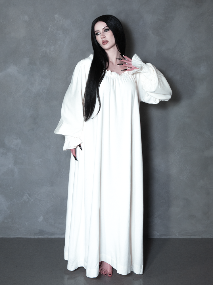 A female model channels high-fashion vampire romance, her darkly enchanting ensemble centered around a premium piece of gothic apparel bearing a sinister yet beautiful ghostly charm.