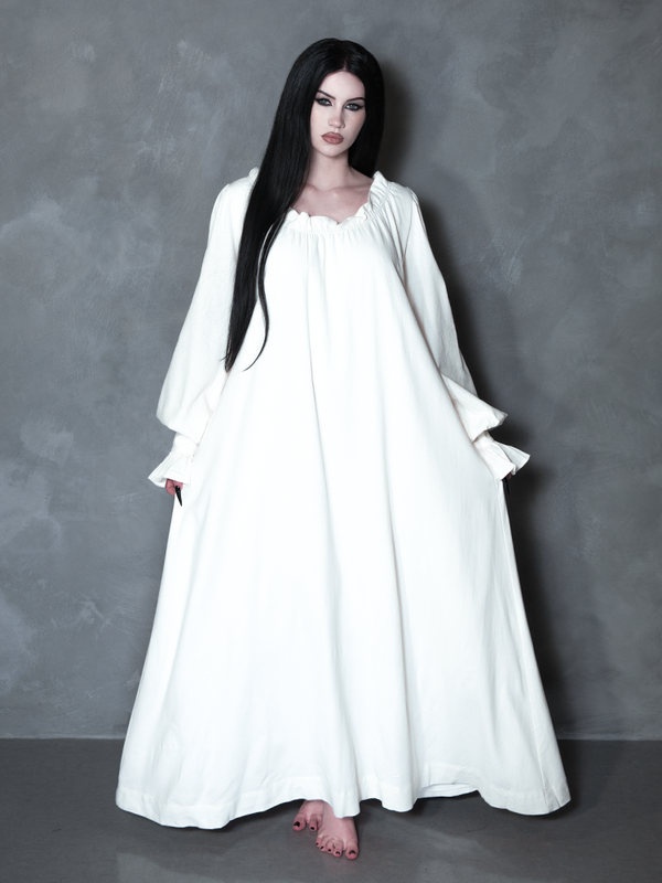Exuding an exquisite Victorian Goth aesthetic, a female model seamlessly blends vintage darkness with modern alternative fashion in a hauntingly elegant pale dress.