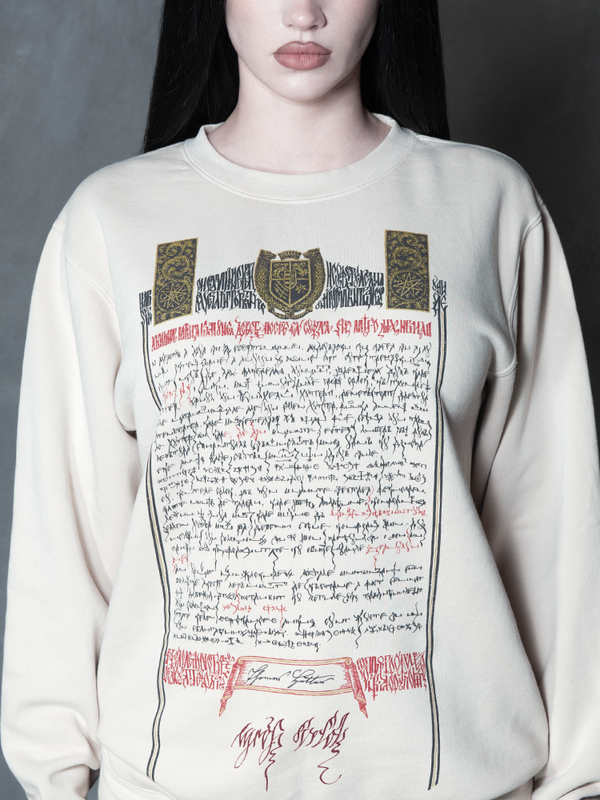 Steeped in romantic melancholy, a model styled in Whimsigoth inspired clothing showcases a comfortable alabaster pullover that captures the timeless spirit of gothic horror.