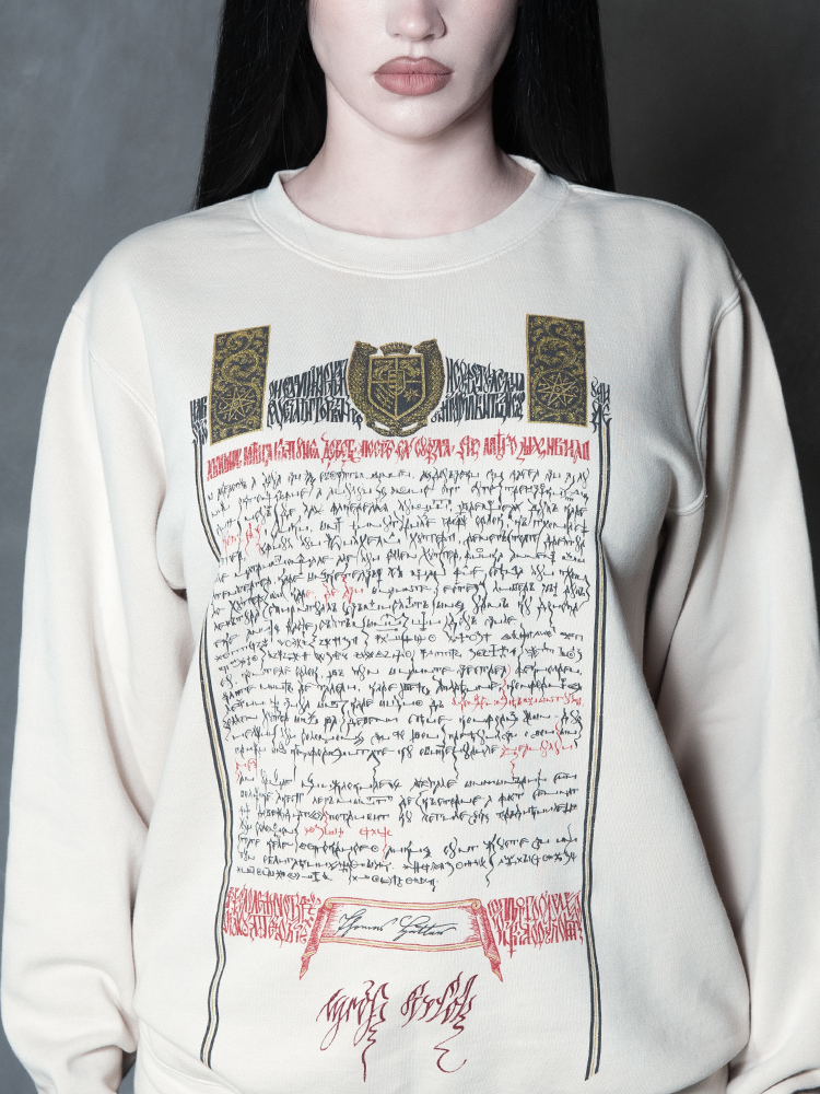 Steeped in romantic melancholy, a model styled in Whimsigoth inspired clothing showcases a comfortable alabaster pullover that captures the timeless spirit of gothic horror.