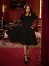 With sweeping flared sleeves, this dress channels the grace of a medieval maiden cloaked in midnight.