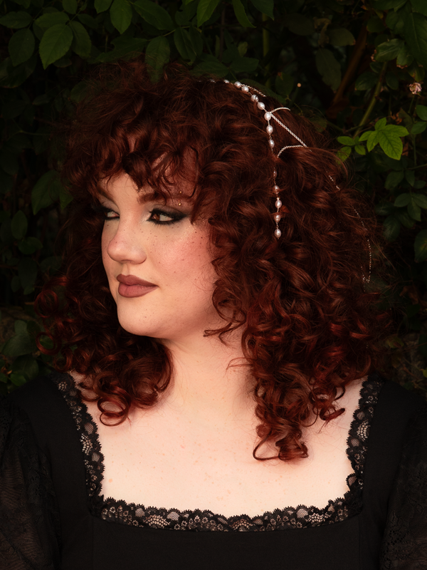 Delicate yet dramatic, this silver hair net shimmers with pearl accents that sway with every movement. Crafted for effortless styling; handle with care to maintain its refined flow.