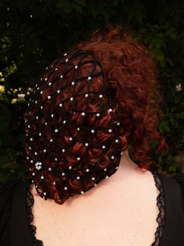 The Black Hair Net with Pearls captures the essence of bygone romance. Its silky threads cradle the hair like nightfall, while soft pearls shimmer with forbidden charm. Ideal for gothic brides or evening seductresses.