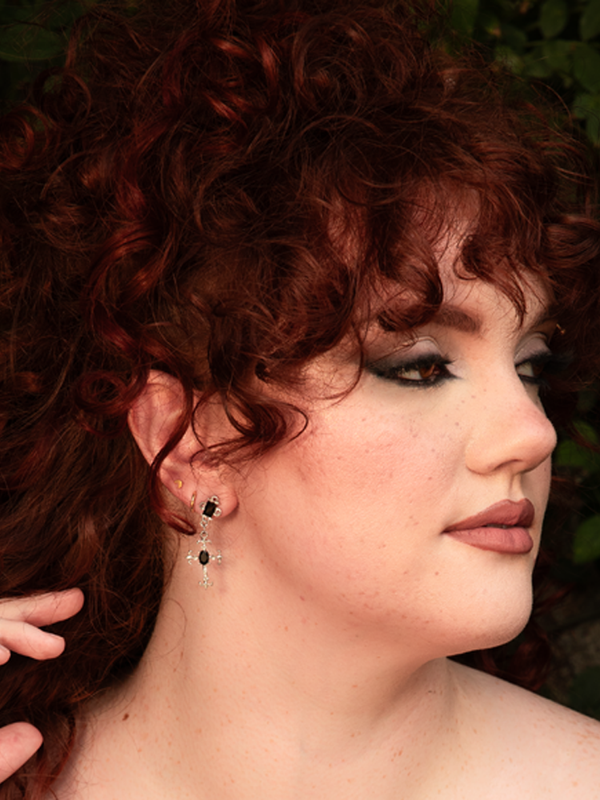 Elegant and ominous, these silver drop earrings cradle faceted black crystals in cross form, swaying with quiet drama. Durable finish, comfortable for all-night wear; store dry to protect shine.