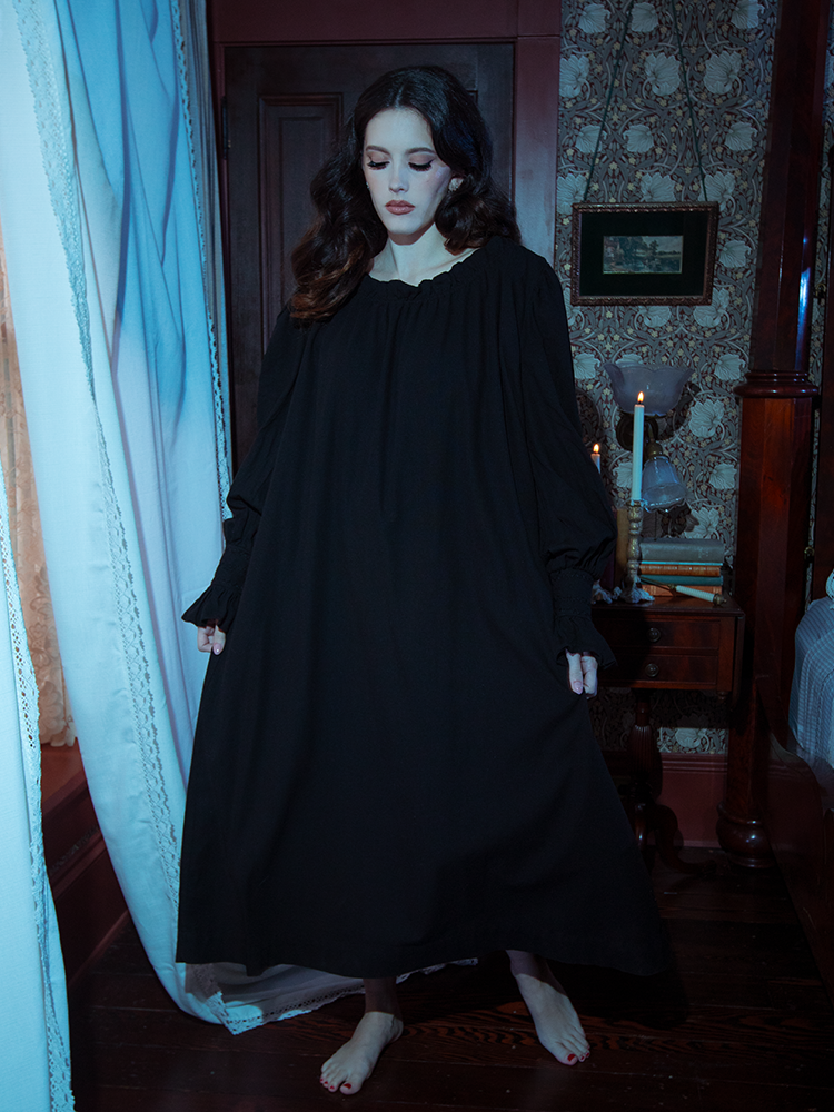 The epitome of vintage allure, this black Victorian sleeping dress showcases a timeless design with flowing fabric and delicate lace-trimmed sleeves.