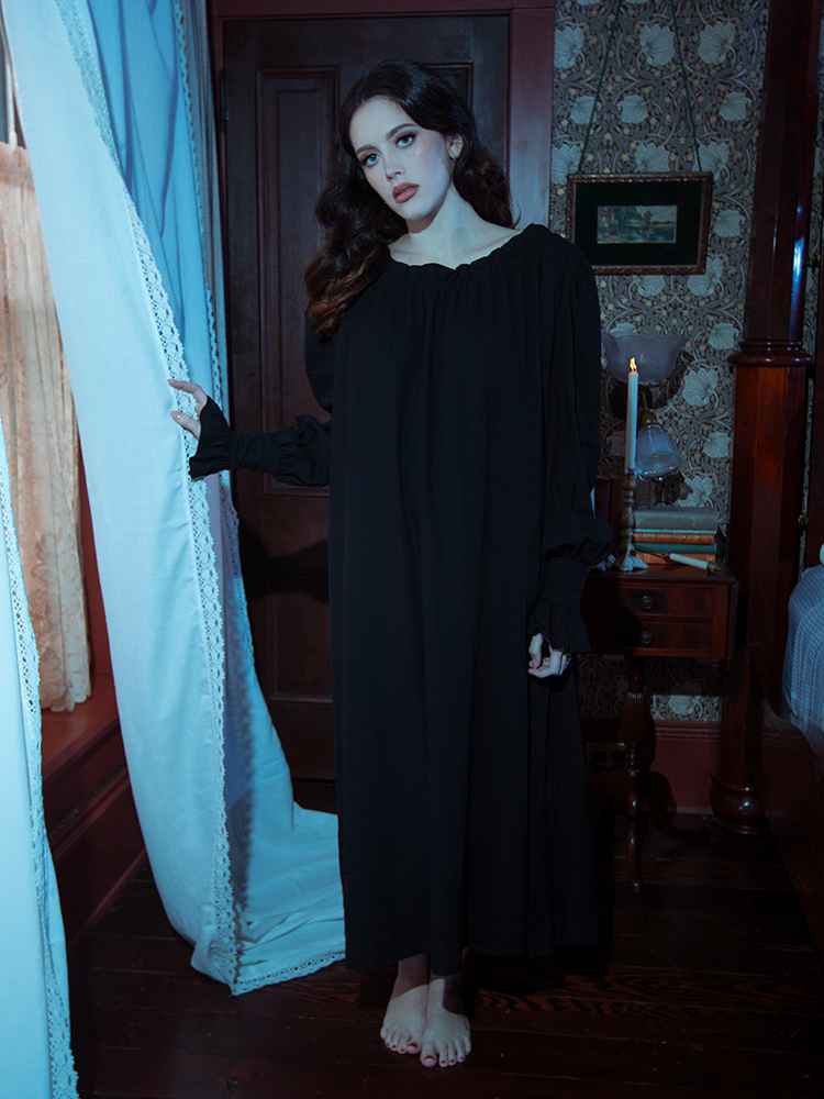 Crafted in deep black satin, the Victorian Sleeping Dress cascades with grace, featuring gathered detailing and subtle gothic embroidery.