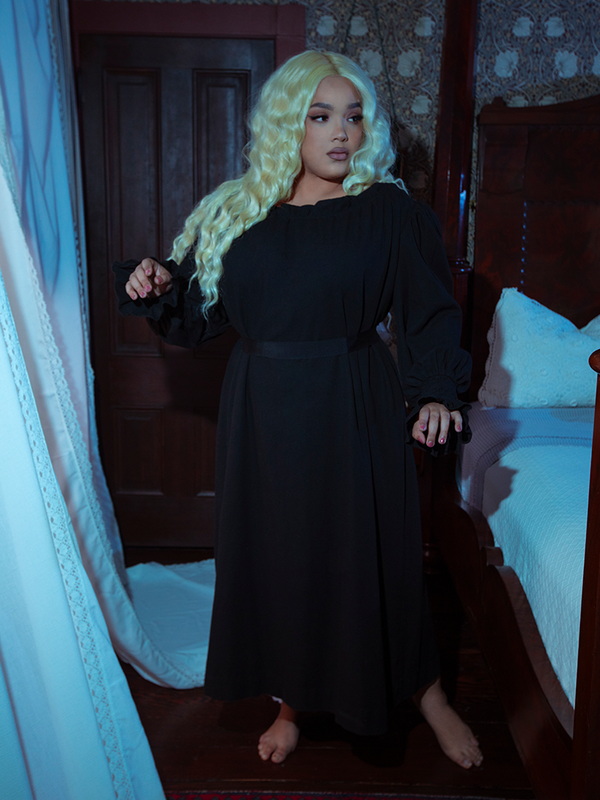 A female model beautifully merges historical romance with alternative loungewear, wearing the Victorian Sleeping Dress in Black.