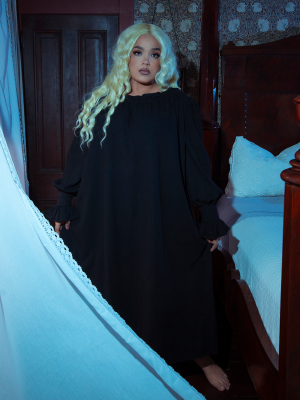 A female model evokes the spirit of a dark fairytale while wearing the dreamy, romantic Victorian Sleeping Dress in Black.