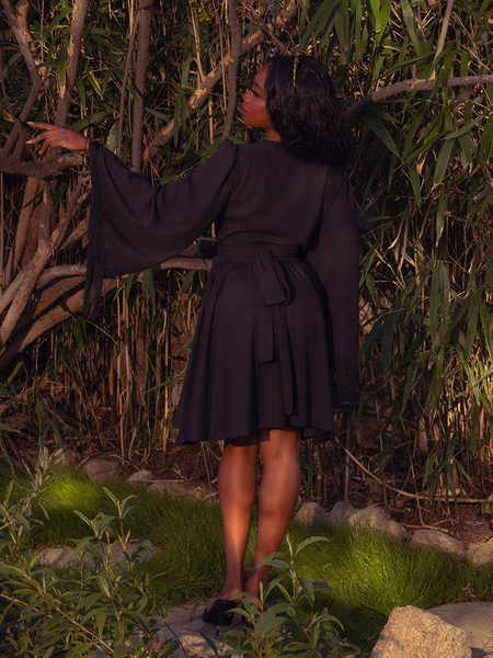 Let the Styx Wrap Dress with Fringe in Black transport you to a world of dark romance. With its sleek design and enchanting fringe, this dress is perfect for twilight soirées and whispered secrets.