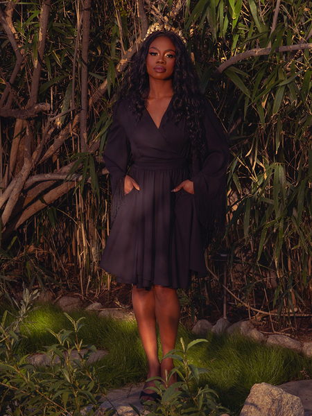 Draped in the Styx Wrap Dress with Fringe in Black, you'll embody the essence of gothic glamour. Its flowing fabric and fringe accents create a captivating aura, ideal for secret encounters and moonlit gardens.