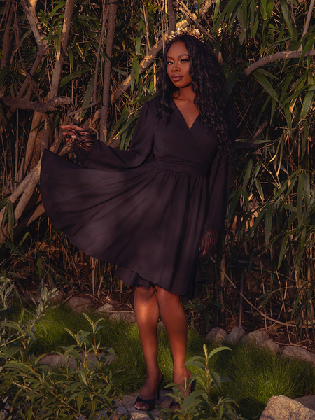 Step into the night with the Styx Wrap Dress with Fringe in Black. This gothic creation, with its flowing fabric and fringe accents, is ideal for twilight gatherings and moonlit dances.