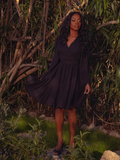 The Styx Wrap Dress with Fringe in Black exudes gothic sophistication. Its sleek silhouette and delicate fringe detailing make it perfect for candlelit soirées and enchanting midnight walks.