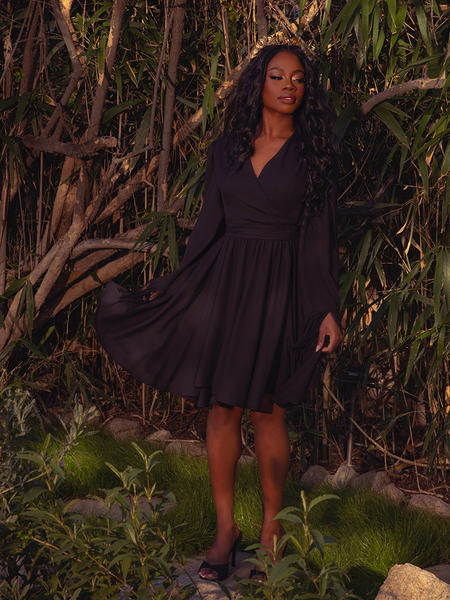 The Styx Wrap Dress with Fringe in Black exudes gothic sophistication. Its sleek silhouette and delicate fringe detailing make it perfect for candlelit soirées and enchanting midnight walks.