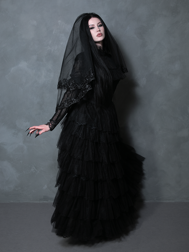 Female model presenting a breathtaking black gothic evening dress steeped in Victorian romanticism.