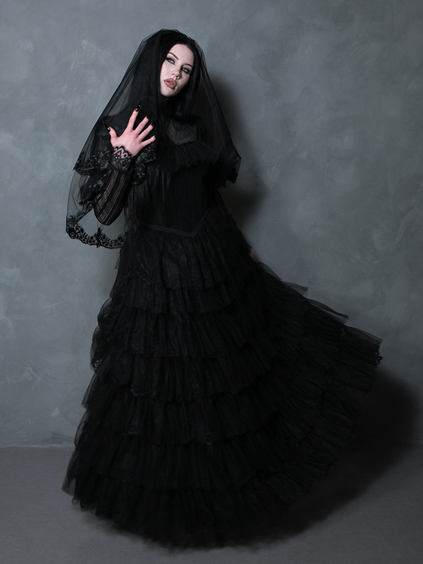 Woman wearing a spellbinding black formal gown highlighting traditional vampiric glamour.