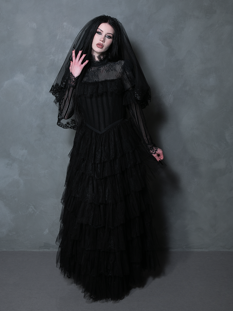 A female model embodying exquisite gothic romance in a dramatic black alternative wedding dress.