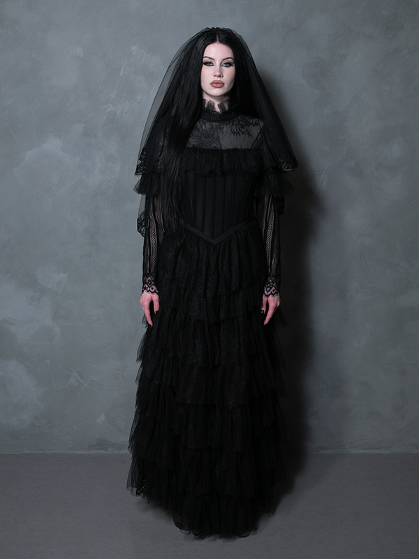 Woman styled in a captivating black romantic gown tailored for the alternative goth bride.